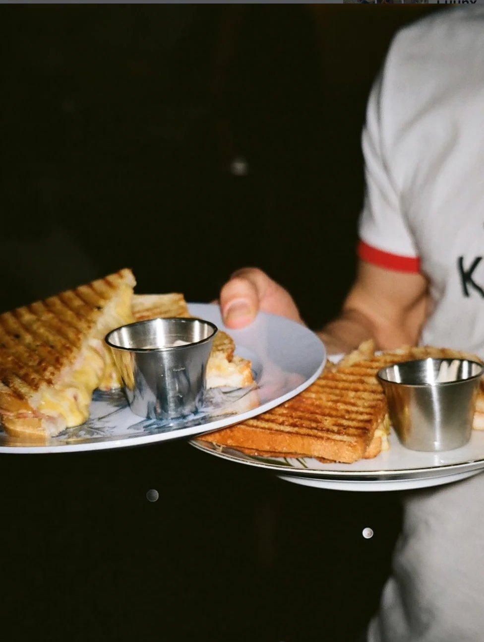 Nahaufnahme von zwei Tellern mit Toast-Sandwiches und kleinen Silberbechern